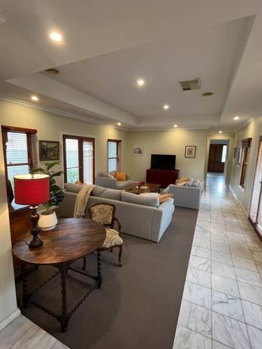 a large living room with couches and a table at Grand retreat in town in Albury
