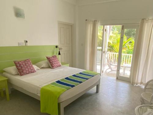 um quarto com uma cama com uma cabeceira verde em Plantation House em Hikkaduwa