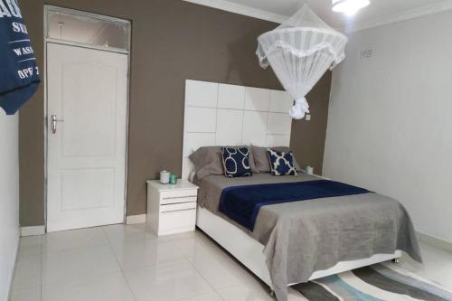 1 dormitorio con 1 cama con edredón azul en Nichi's Guesthouse - Cosy 3 bedroom with breakfast en Blantyre
