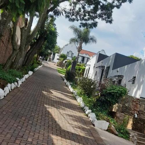 a brick road with trees on the side of it at Goshen in Johannesburg