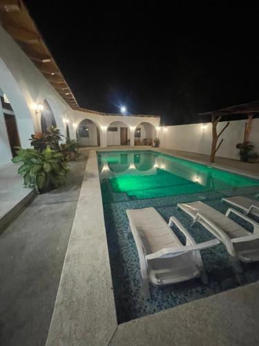 einen Pool mit 2 Liegestühlen und einem Pool in der Unterkunft CASA PARAISO 
