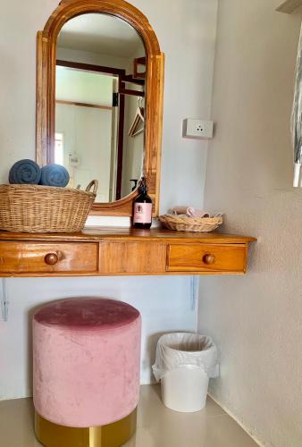 a bathroom with a mirror and a pink stool at Funwan Hotel in Li