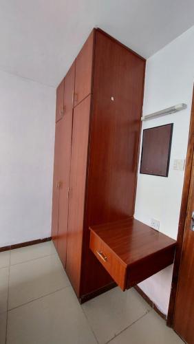 a room with a wooden cabinet and a desk at Furnished Homes Nakuru with pool & GYM in Nakuru