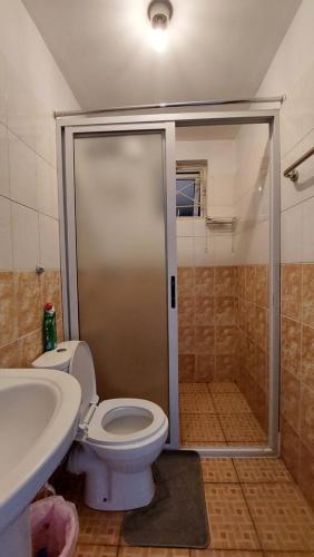 a bathroom with a shower and a toilet and a sink at Furnished Homes Nakuru with pool & GYM in Nakuru