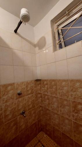 a bathroom with a shower with a window at Furnished Homes Nakuru with pool & GYM in Nakuru
