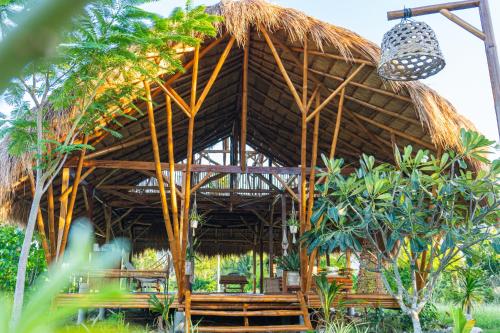 um grande edifício de bambu com telhado de palha em Tongo Hill Cottages em Moalboal