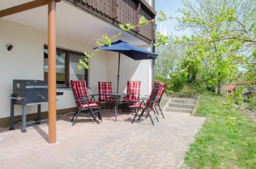 eine Terrasse mit einem Tisch, Stühlen und einem Sonnenschirm in der Unterkunft Ferienwohnung Kobelsberg in Aufseß