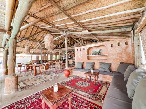 a living room with a couch and a table at Bungalow Cafe Gili Beachfront in Gili Meno