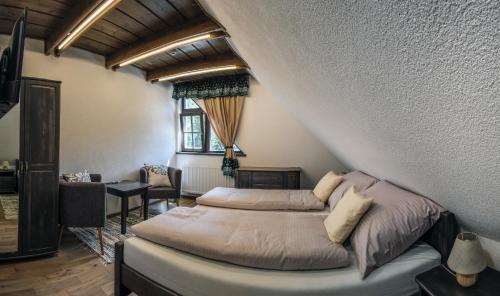 a bedroom with a bed and a desk and a window at Stará Zvonica in Nižná Boca
