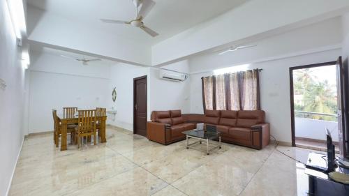een woonkamer met een bank en een tafel bij Downtown Manor-Panavila in Trivandrum