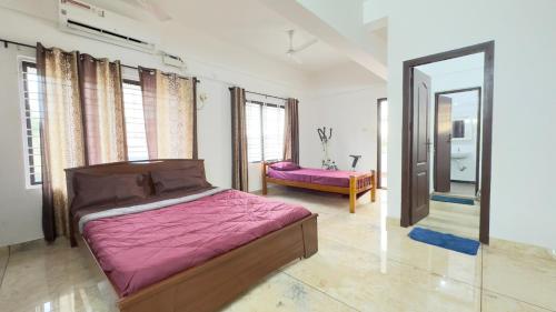 een slaapkamer met een bed en een spiegel bij Downtown Manor-Panavila in Trivandrum