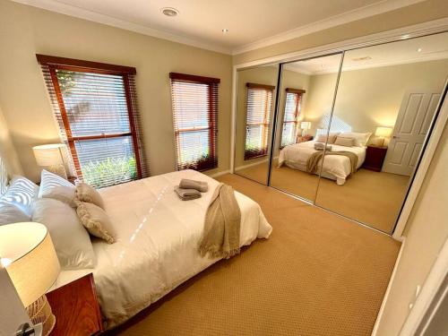 a bedroom with two beds and a large mirror at Grand retreat in peaceful street in Wodonga