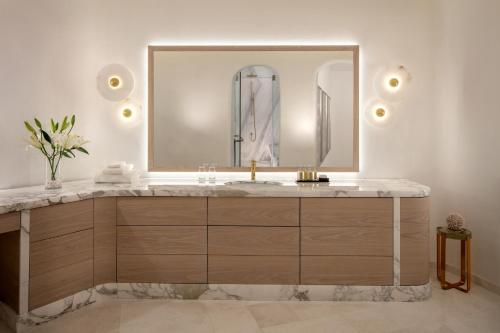 a bathroom with a large mirror and a sink at Anantara Santorini Abu Dhabi Retreat-Adults Only in Al Rahba