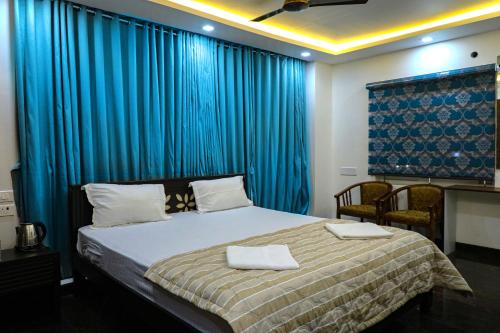 a bedroom with a bed with blue drapes at JP RESIDENCY in Yelagiri