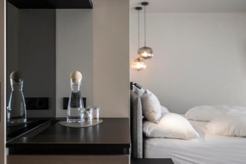 a bedroom with a bed and a table with glasses at Hotel Viertler in Avelengo