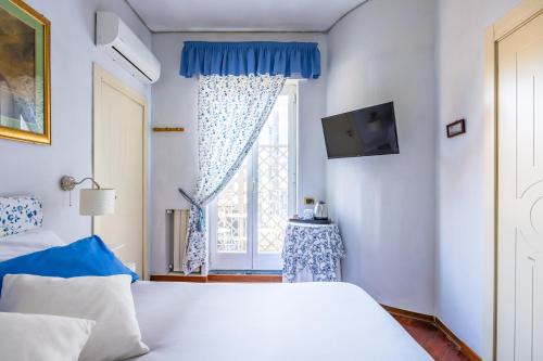 1 dormitorio con cama blanca y ventana en La Casa Di Bruno Napoli, en Nápoles