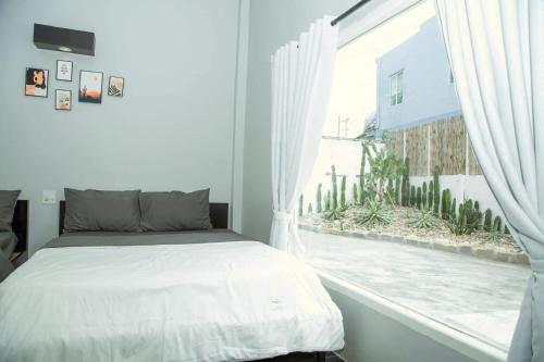 a bedroom with a bed and a large window at Evergreen Tree Homestay in Phan Thiet