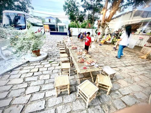 a group of wooden tables and chairs on a patio at Evergreen Homestay in Phan Thiet