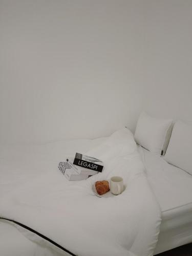 a white bed with a book and two donuts on it at Jeongdam in Seoul