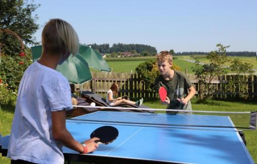 a group of people playing ping pong on a ping pong table at Wolfeicherhof in Eggstätt