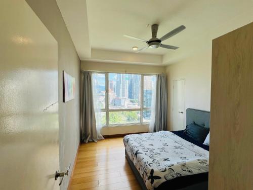 吉隆坡的住宿－Crest residence，一间卧室配有一张带吊扇和窗户的床。