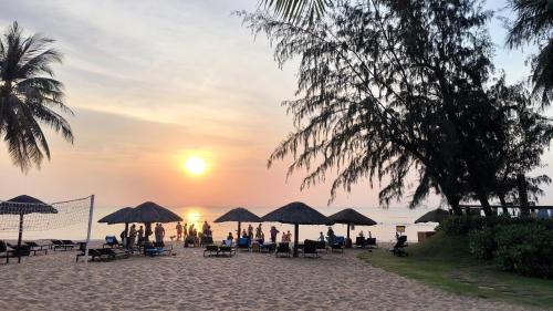 富國的住宿－FLORA Hotel Phu Quoc，一群人坐在海滩上的伞下