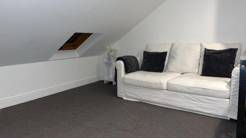 biała kanapa z czarnymi poduszkami w pokoju w obiekcie Sunrise Retreat w Londynie