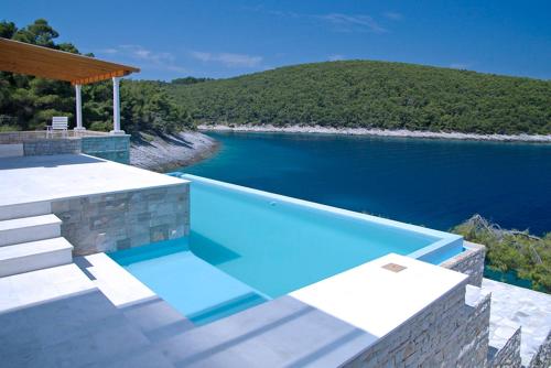 una piscina con vistas a un cuerpo de agua en STONE VILLAGE, en Vela Luka