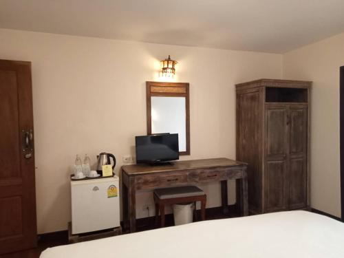 a bedroom with a bed and a mirror and a television at Sripat Guesthouse SHA Extra Plus in Chiang Mai