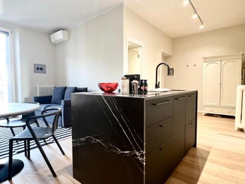 een keuken met een zwart eiland in de woonkamer bij ComeCasa Fashion apartment Mantova in Milaan