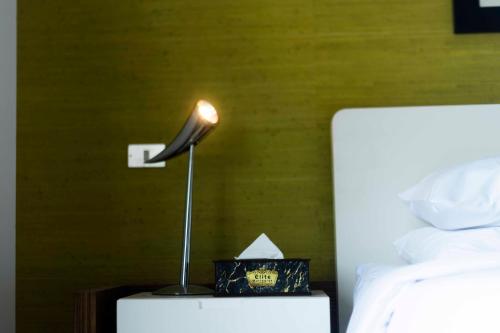 a lamp on a night stand next to a bed at El Gouna Elite Worldwide Sea & Garden Residences - Hurghada, Egypt in Hurghada