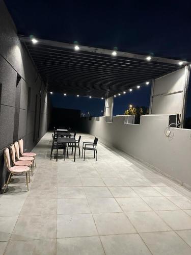 un gruppo di tavoli e sedie su un patio di notte di النظافه والجوده a Riyad