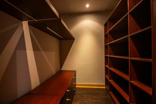 a walk in closet with wooden cabinets and shelves at El Gouna Elite Worldwide Sea & Garden Residences - Hurghada, Egypt in Hurghada
