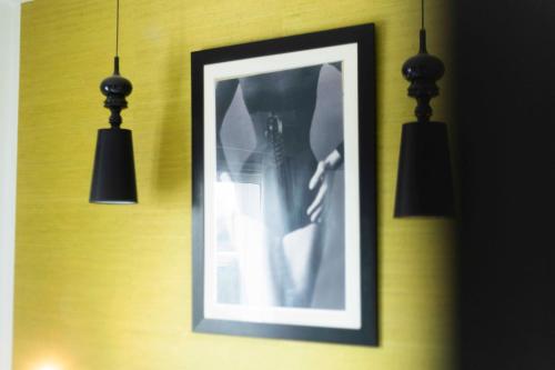 a framed picture hanging on a wall with two lights at El Gouna Elite Worldwide Sea & Garden Residences - Hurghada, Egypt in Hurghada
