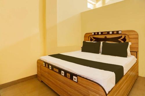a bedroom with a large bed with a wooden headboard at OYO Flagship Hotel Suraj Villa in Nārnaul