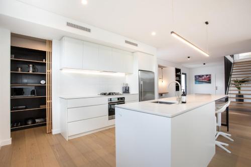 a kitchen with white cabinets and a white counter top at Bluff Street Home by the BnB Collection in Albany