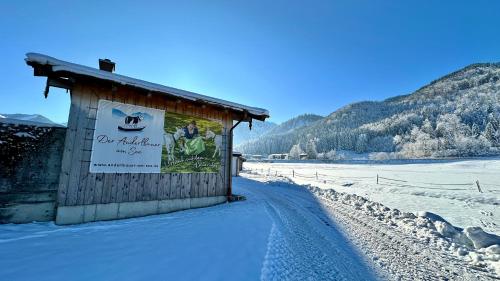 a sign on the side of a building in the snow at Der Anderlbauer am See in Schliersee