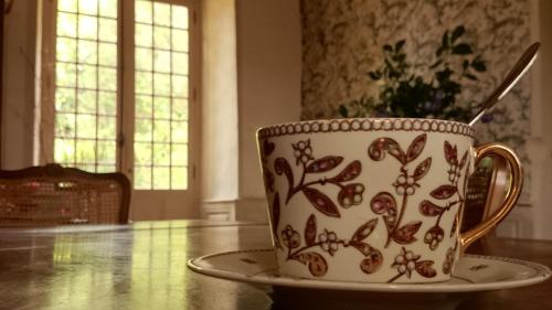 a coffee cup sitting on a table with a saucer at Chateau de Durianne in Le Monteil