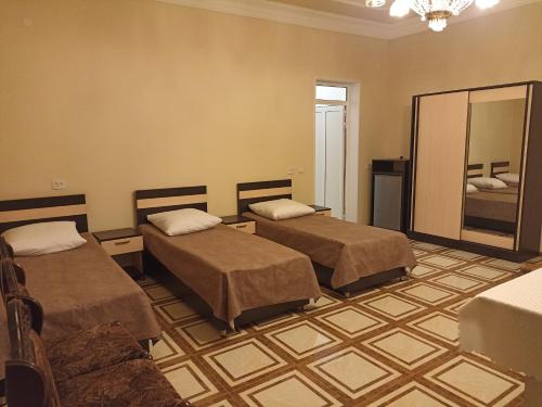 a hotel room with two beds and a mirror at Erazank Hotel in Gyumri