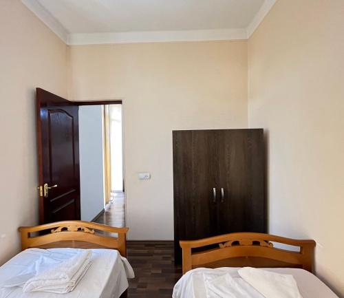 um quarto com duas camas e um armário preto em Saryan 2 em Yerevan