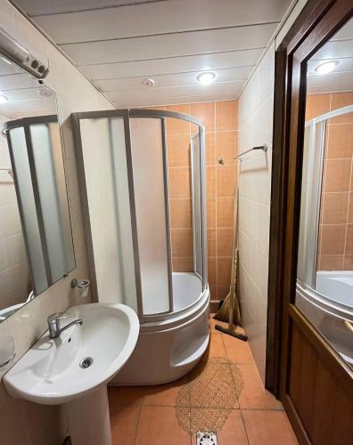 uma casa de banho com um chuveiro, um lavatório e uma banheira em Saryan 2 em Yerevan