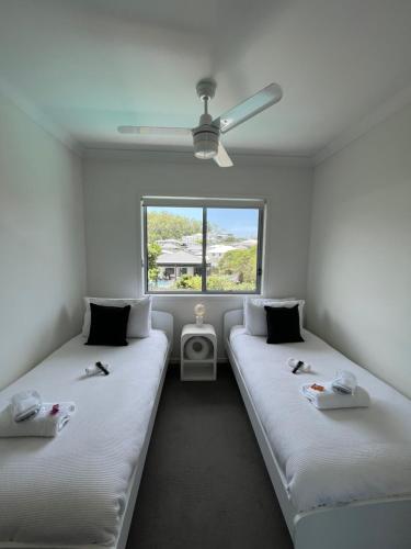 two beds in a room with a window at Upper Coomera Castle 2 in Gold Coast
