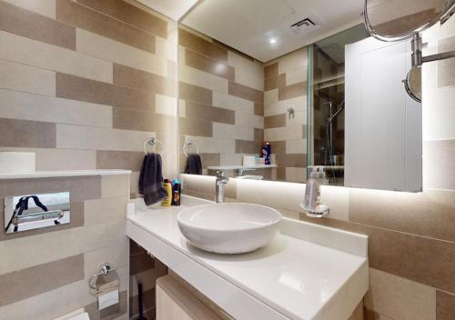 W łazience znajduje się biała umywalka i lustro. w obiekcie Beachfront Haven w Dubaju