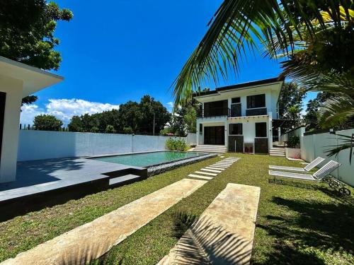 einen Hinterhof mit einem Pool und einem Haus in der Unterkunft Solitary Golf Home w/ Pool in Davao City