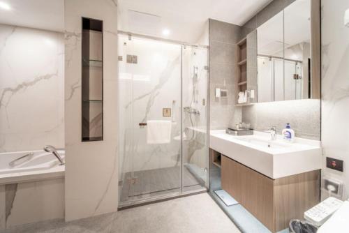 uma casa de banho com um chuveiro, um lavatório e um WC. em CM Service Apartment Suzhou Science Amp Technology Town em Suzhou