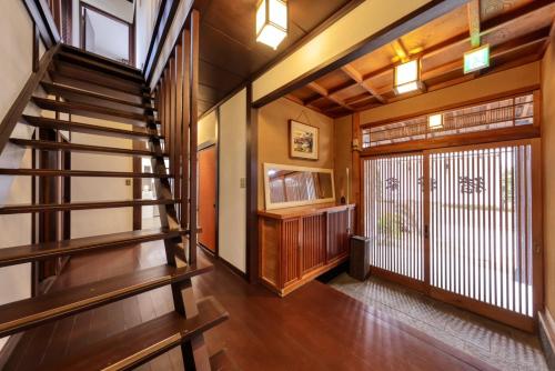 a hallway with a staircase in a house at Yoshimura igariya in Azagawa