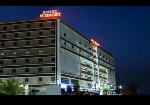 un edificio con un letrero de neón encima en Hotel Shree Regency Ahmedabad en Ahmedabad