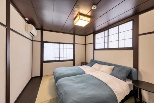 ein Schlafzimmer mit einem Bett und zwei Fenstern in der Unterkunft Yoshimura igariya in Azagawa