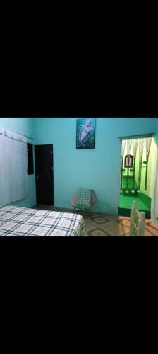 1 dormitorio con cama y pared azul en Habitación privada Mazunte, en Santa María Tonameca