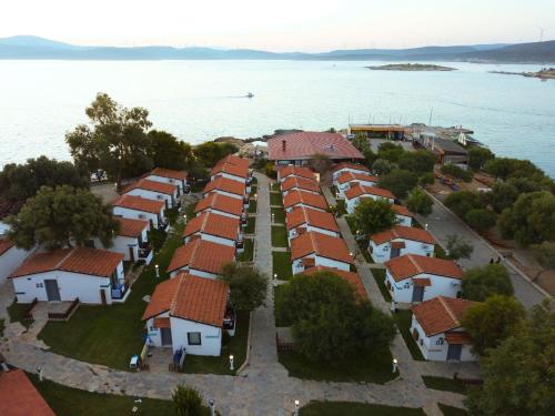 eine Luftansicht einer Gruppe von Häusern am Wasser in der Unterkunft Maya Bistro Hotel & Beach in Siğacık